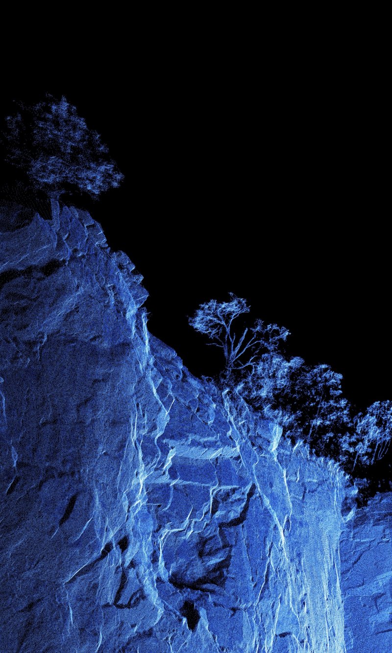 Mountain Quarry A: blue point cloud scan of a quarry rock face and trees against black